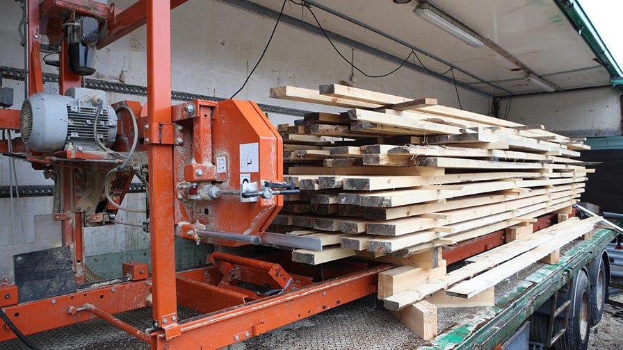 To make his sawmill easily movable, John´s solution was to to put the whole thing on wheels, into a truck container